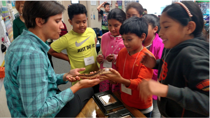 An educator engaging in environmental learning with students.