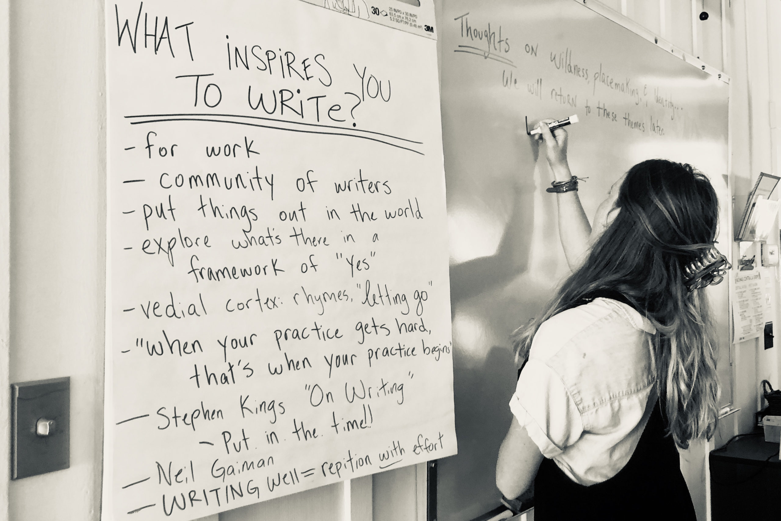 Allie Rigby writing on a white board next to poster that says "What inspires you to write?"